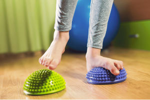 Child doing flat feet exercises for kids using balance pods to strengthen arches and improve foot alignment