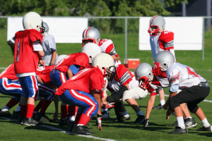 Youth football injury prevention through proper technique training with helmets and protective gear