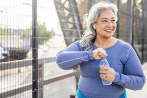 Active woman drinking water from a bottle during a workout for proper sports hydration