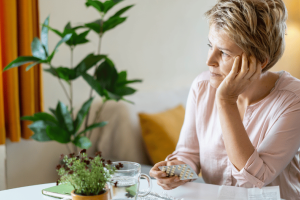Woman with low estrogen symptoms sitting at a table
